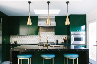 Deep emerald cabinetry and white hexagonal backsplash