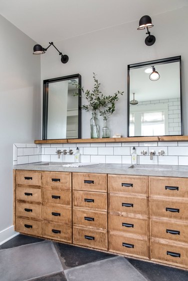 rustic industrial bathroom with concrete countertop and white subway tile backsplash