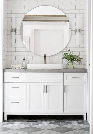 bathroom with concrete countertop and walls with white subway tile
