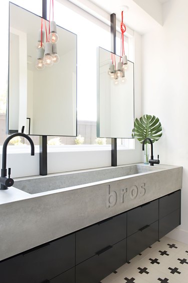 long concrete trough sink in black and white bathroom