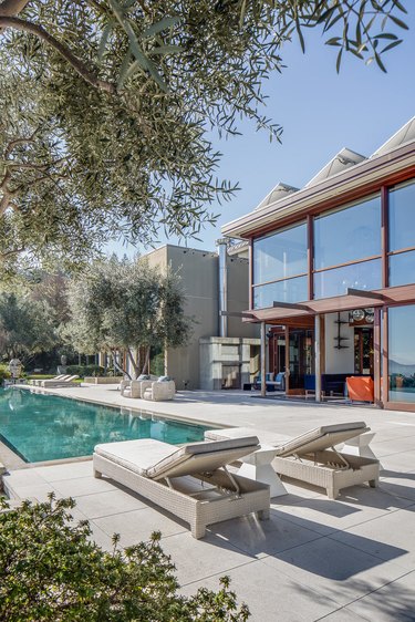 Midcentury backyard pool design with midcentury furniture and linear design accents