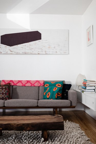 Grey sofa with artwork on wall and wood coffee table