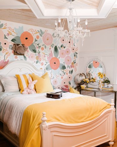 yellow kids bedroom idea with floral accent wall and yellow bedding