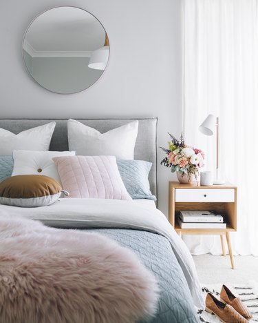 Pastel bedding and bright wood nightstand