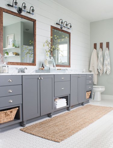 farmhouse bathroom with shiplap wall and gray vanity cabinet