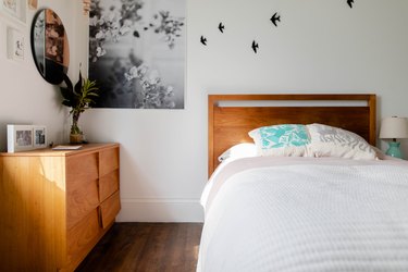 bedroom space with wooden furniture and bird decals on the wall