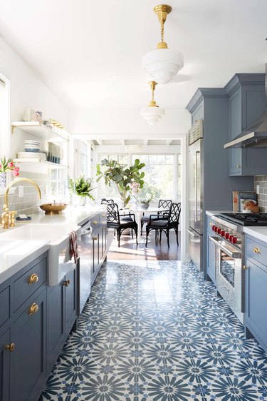 galley kitchen with patterned floor tile and blue cabinets