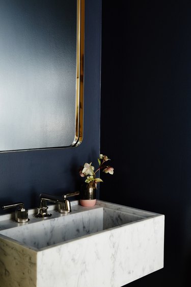 blue bathroom with wall mount marble sink