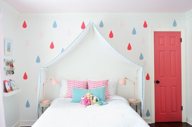 modern kids bedroom idea with pink closet door and bed canopy