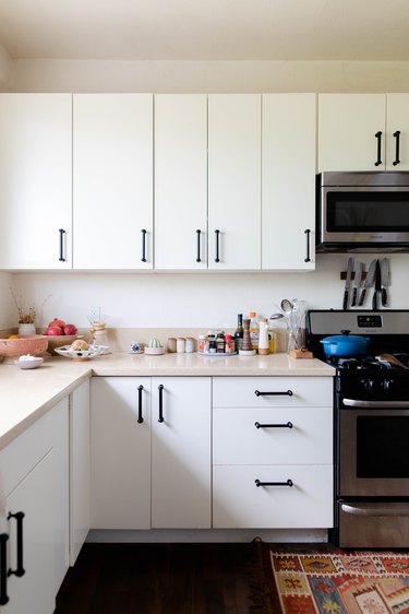 white kitchen cabinetry, range and microwave