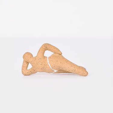 ceramic in the shape of a figure lying down with a hand on their hips