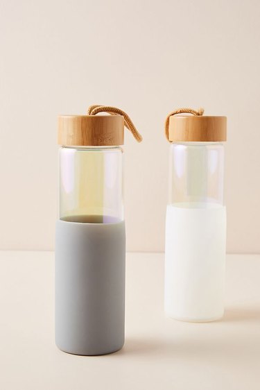 white and grey glass water bottles with wood tops