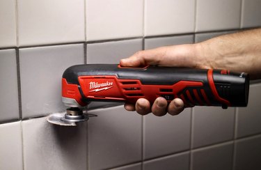 Multi-tool removing grout.