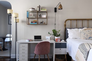 Bed next to desk with pink chair