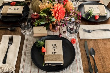 Rustic table setting with black plates and flatware