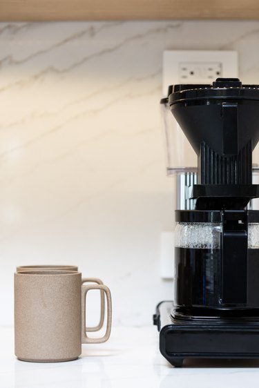 coffee machine and cup of coffee on kitchen counter