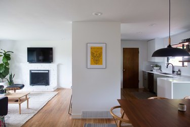 Open living room and kitchen space with new wood flooring.