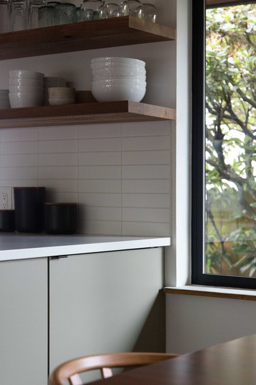 Open shelving and white subway backsplash in kitchen.