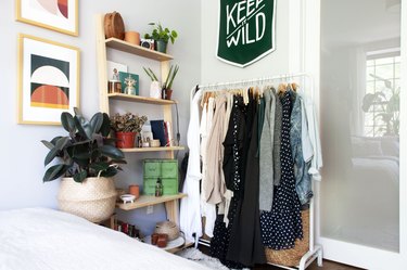 small bedroom idea with clothing rack near leaning shelving unit