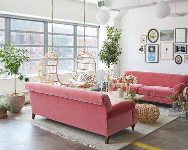 contemporary living room with velvet pink sofas and hanging chairs