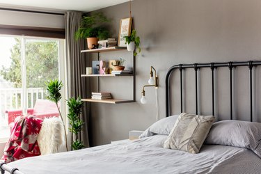 small bedroom idea with shelving on wall near bed and window