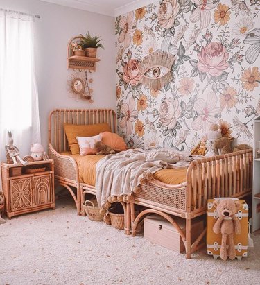 rattan bed and nightstand in bohemian kids bedroom idea with floral wallpaper