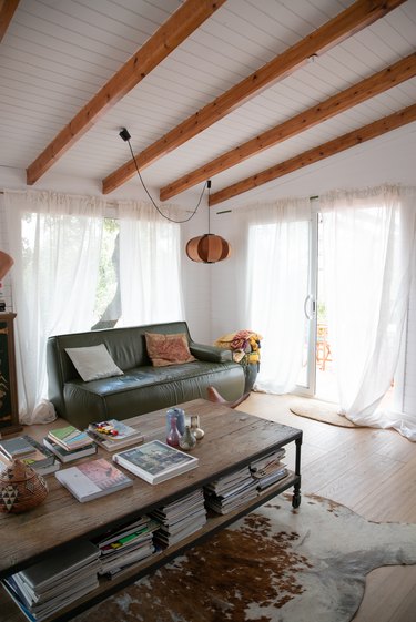 Living room with green leather couch and Coderch pendant lamp