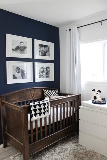 blue nursery idea with framed photos hanging above wooden crib