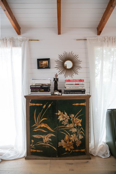 Green vintage, ornate dresser with books on top