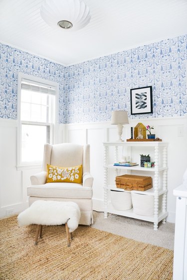 Blue nursery idea with patterned wallpaper and white wall paneling