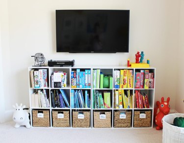 Color-coded playroom storage idea with books and woven baskets