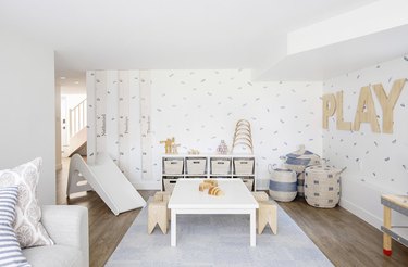 kids playroom idea with slide and table and stools for arts and crafts and sofa