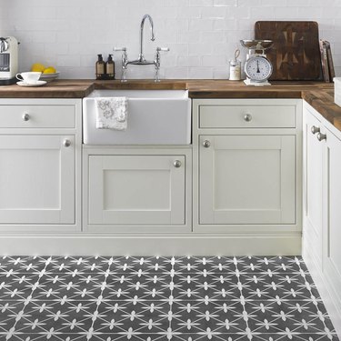 Gray starburst floor tile in country kitchen with wood countertops