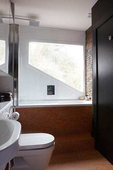 modern black bathroom with cork flooring and brick accent wall