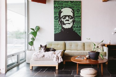 focus on couch with dog and large poster, slate flooring