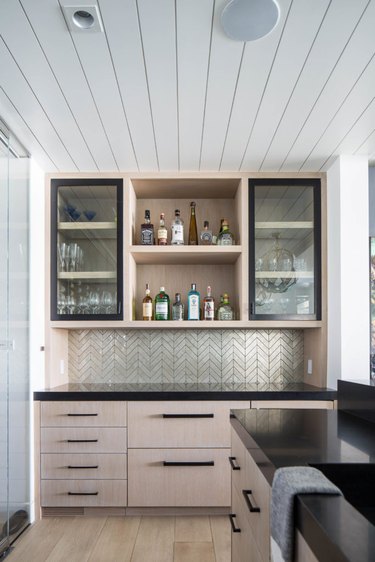 kitchen space with light wooden cabinets and glass kitchen cabinets