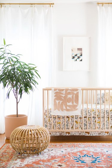 modern nursery idea with rattan decor and patterned rug
