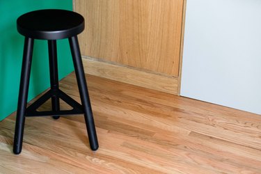 closeup of stool against green wall and hardwood floors