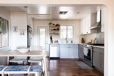 white open kitchen with gray base cabinets and white upper cabinets