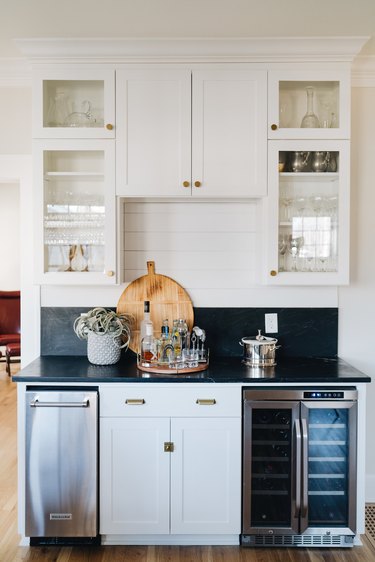 kitchen space with white glass cabinets and dark countertop