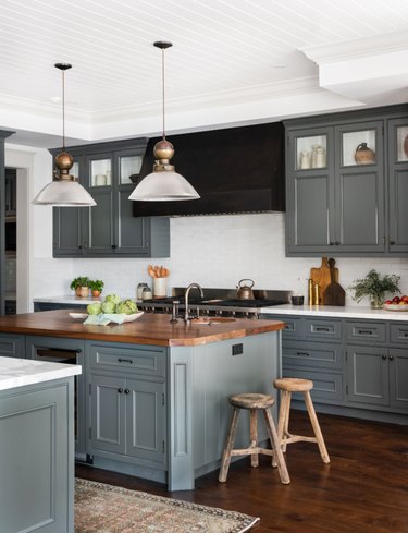 kitchen space with dark cabinets and two hanging lights