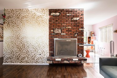 accent wall and brick fireplace with hardwood floors