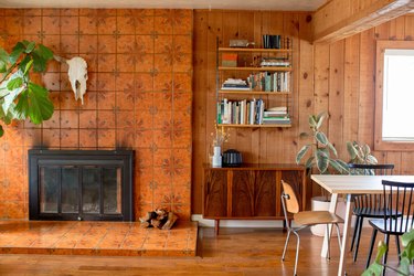 accent wall with fireplace in dining room with hardwood floors