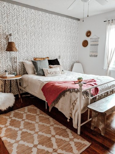 bohemian bedroom idea with red, white, and green decor and stenciled accent wall