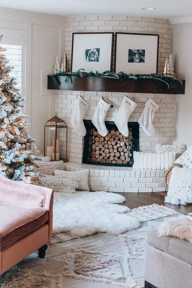 White  farmhouse Christmas decorating idea for living room with stockings, textiles, and Christmas tree