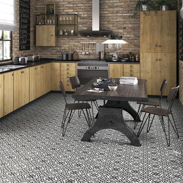 industrial kitchen with black and white ceramic floor tile and brick walls