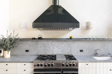 Gray soapstone countertops with white cabinets and black hood