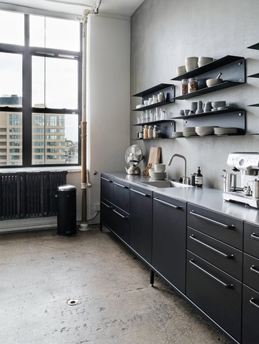 Black cabinetry and shiny silver countertops