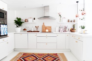 white kitchen with brass hardware and copper pendant lights