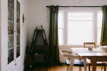 dining room with built-in bookshelf, green curtains, wood dining table and hardwood floor